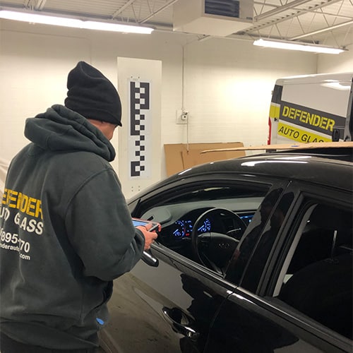 defender employees repairing auto glass